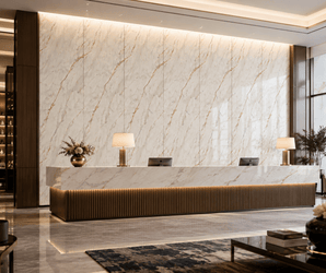 Marble front desk in a modern hotel lobby with floral accents and decorative wall panels under soft lighting.