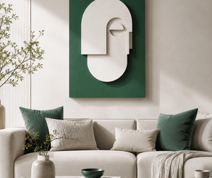 Emerald green wall art above neutral sofas with green pillows and a round table in a modern living room setting.