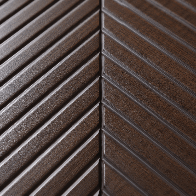 Close-up of the Espresso Chevron PS Wall Panel, showcasing its dark brown finish and distinctive chevron pattern formed by diagonal grooves that converge along a central line—a standout example of decorative wall panel design, perfect for use as a feature wall.