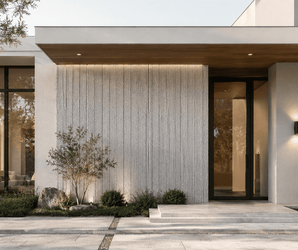 Modern house exterior with large windows, textured white walls featuring stylish Linear Soft Stone wall cladding, wood accents, potted plants, and minimalist landscaping along a stone pathway. Trees are visible through the glass.