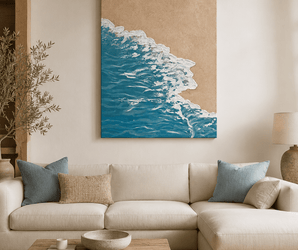 Wallsmark INC Ocean Shore Coastal Wall Art above beige sofa with blue pillows and wooden table in bright living room.