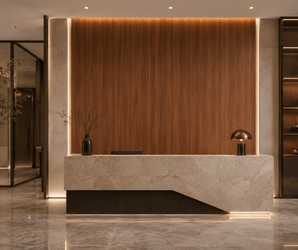 Reception desk with marble countertop, wooden wall clad in Bamboo Charcoal Board in a lobby setting.