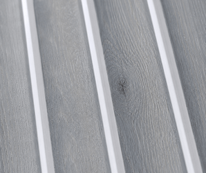 Close-up of the Silver Ash Fluted PS Wall Panel, featuring light gray wood tones with distinct grain patterns and sleek vertical white dividers—an ideal choice for an elegant interior or decorative wall panel in any modern setting.