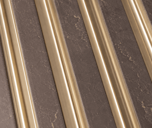 The Taupe Gold Fluted PS Wall Panel features diagonal gold metallic strips set against a brown, marble-textured surface, creating a striking modern geometric pattern with alternating materials—an ideal choice for luxury wall panels that elevate any interior.