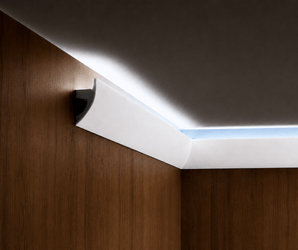 White Curved LED Baseboard lighting highlights the top edge of wood-paneled walls with a seamless modern finish.